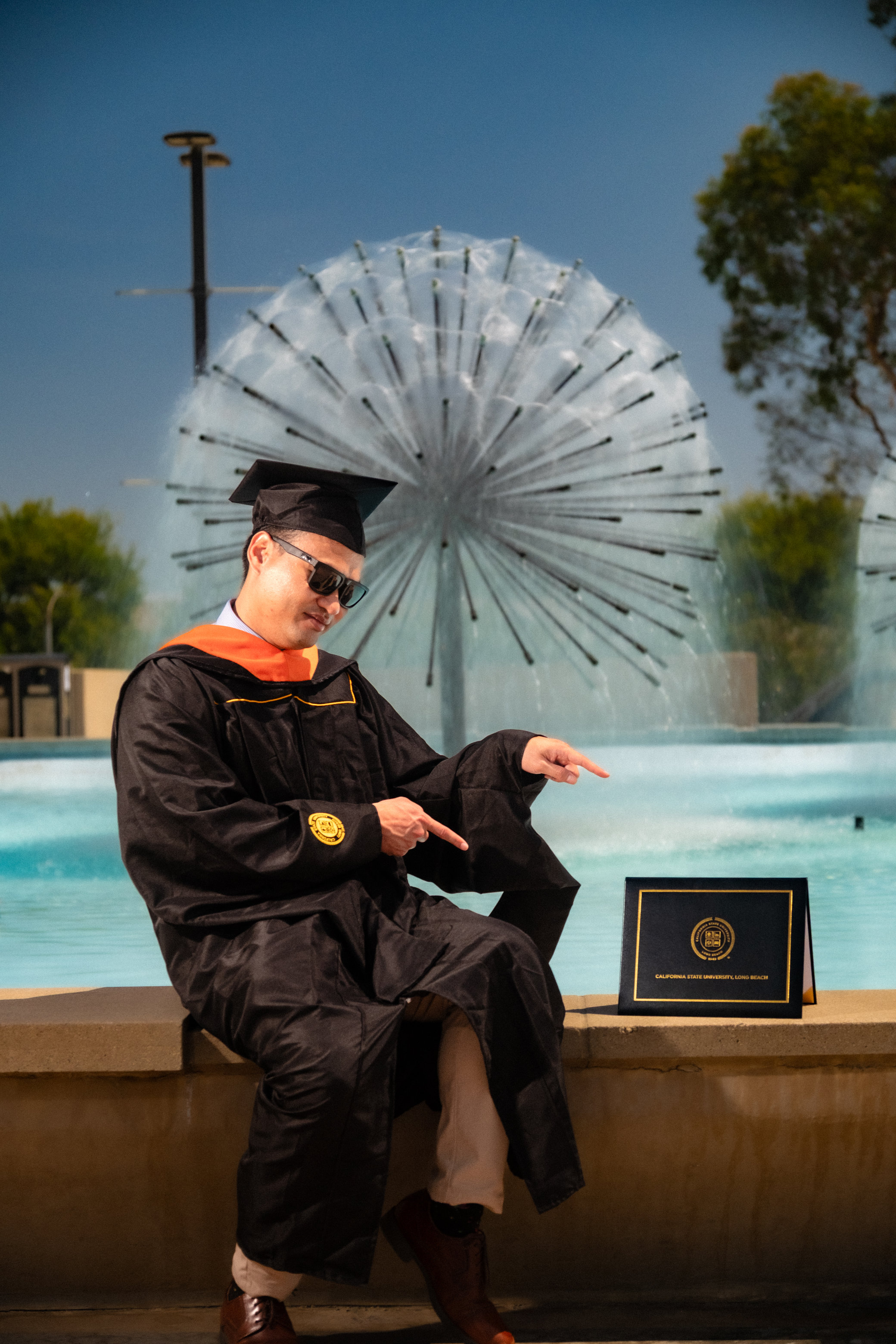 Graduate in gown posing with diploma
