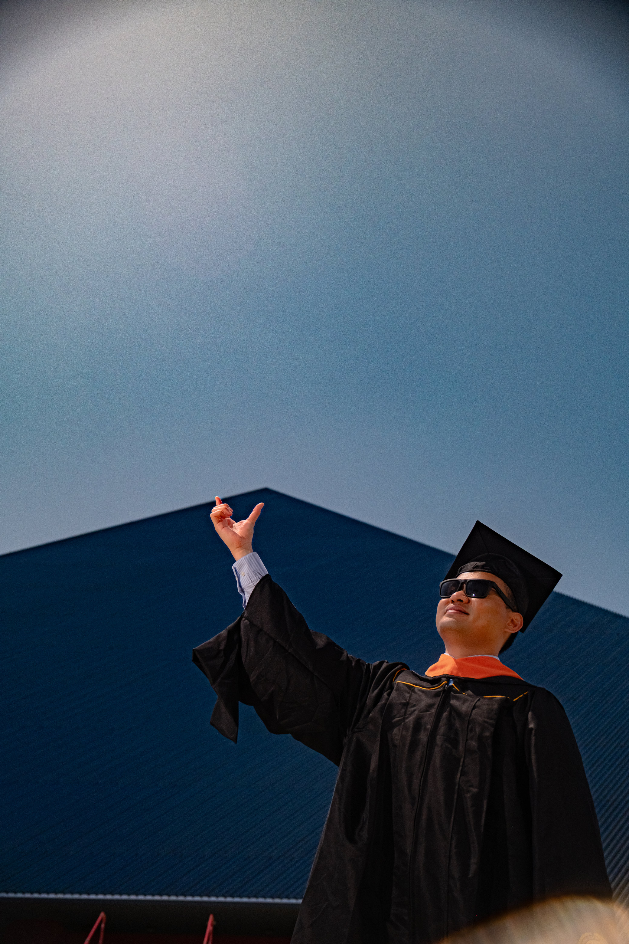 Graduate pointing skyward